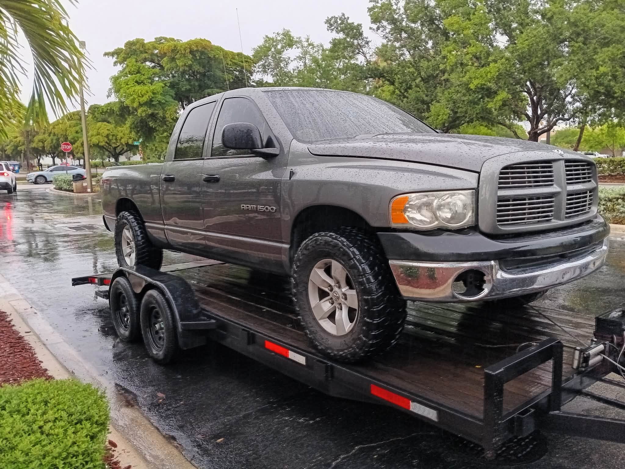 Dodge Ram pickup loaded securely during rainy weather transport.