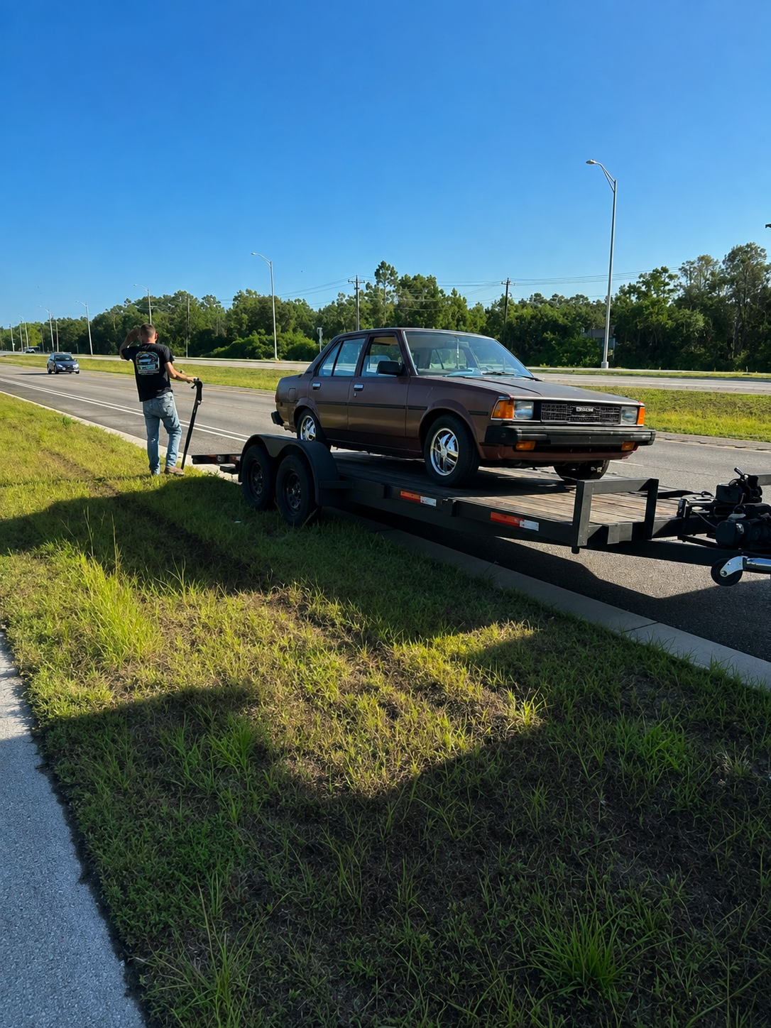 Classic vehicle transported with owner on-site during pickup.